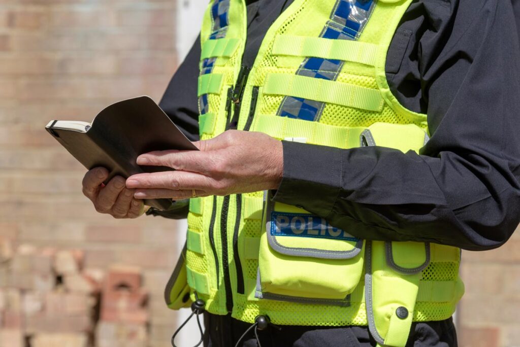 a woman police officer holding an open black notebook