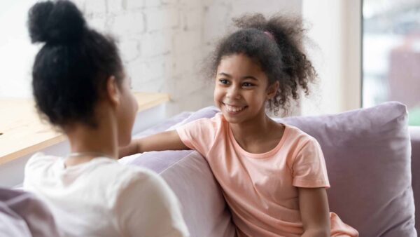 Happy,Little,Girl,Sit,On,Couch,With,Young,Mom,Or