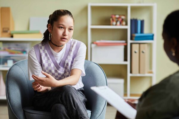 Teenage,Girl,Sitting,On,Armchair,And,Talking,About,Her,Problems