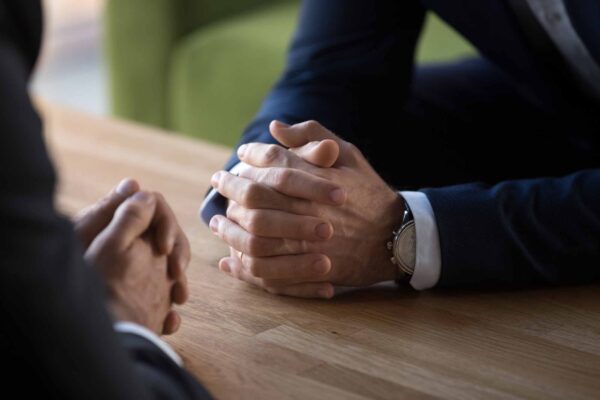 Clasped,Male,Hands,Of,Two,Businessmen,Negotiate,At,Table,,Hr