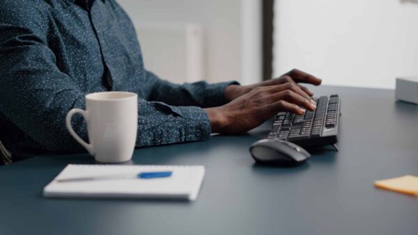 Man typing on computer keyboard in living room