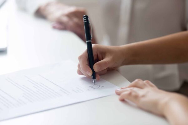 Close,Up,Of,Female,Job,Candidate,Hold,Pen,Put,Signature