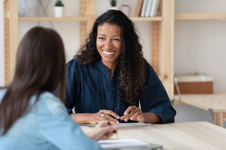 Woman talking with female colleagues at office team meeting.