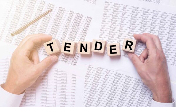 Tender,Word,On,Wooden,Cubes,On,Office,Table,Full,Of