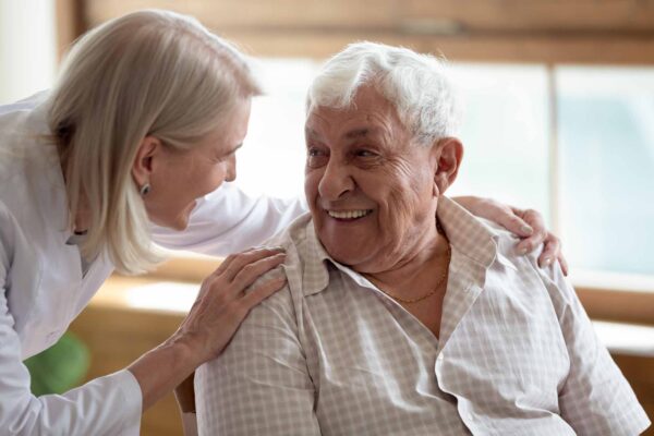 Nurse smiling with elderly man