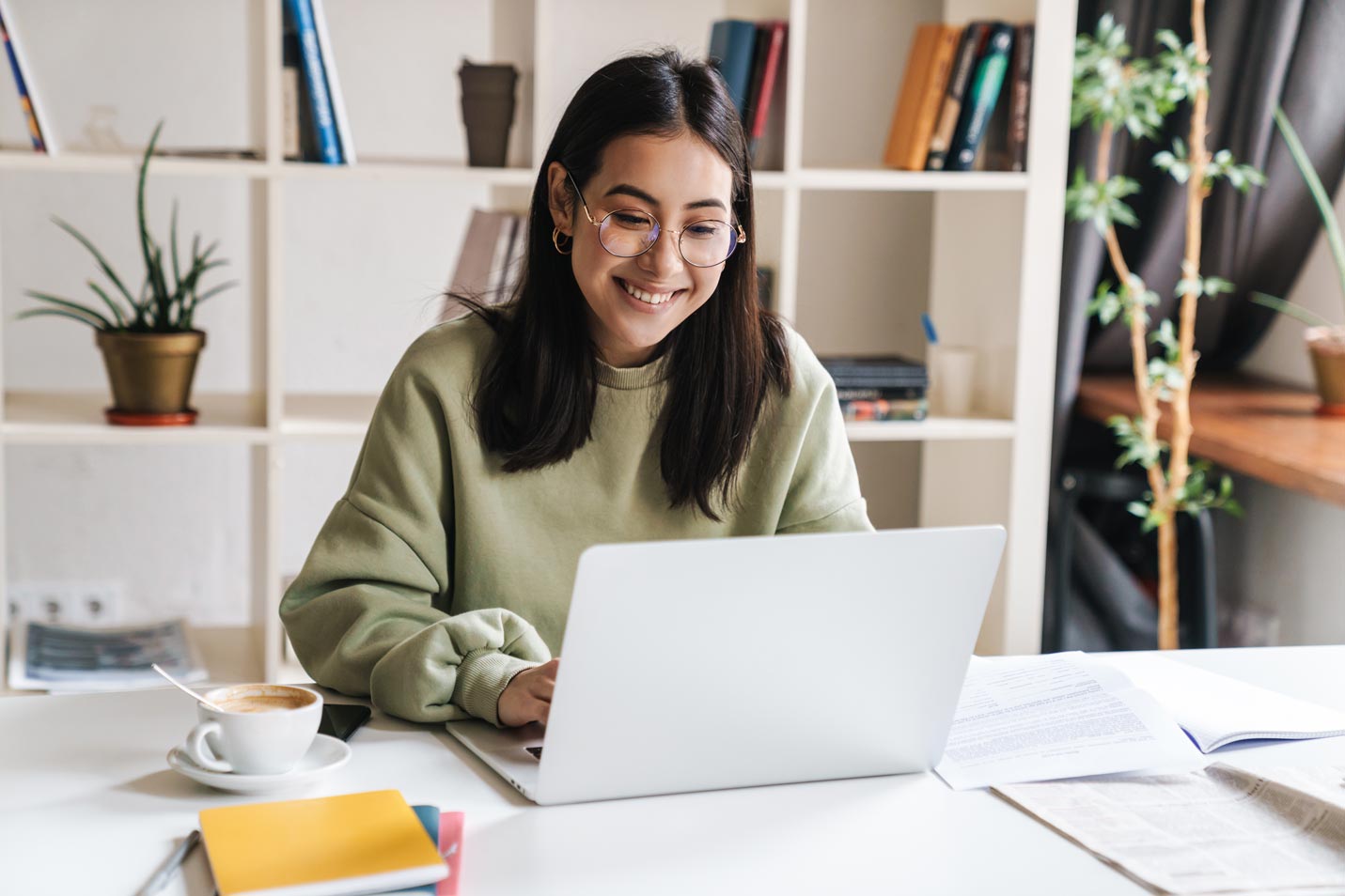 woman smiling and working on laptop