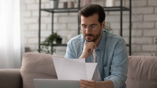 Close,Up,Serious,Man,Wearing,Glasses,Reading,Letter,,Payment,Notification,