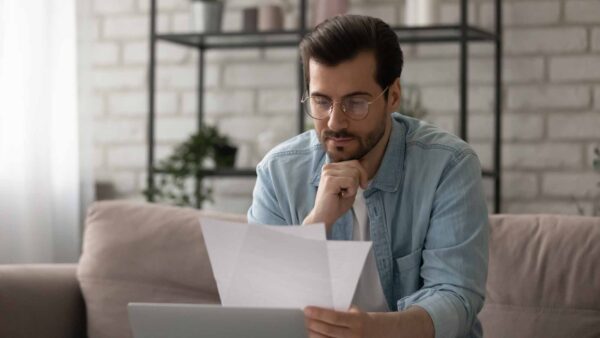 Close up serious man wearing glasses reading letter