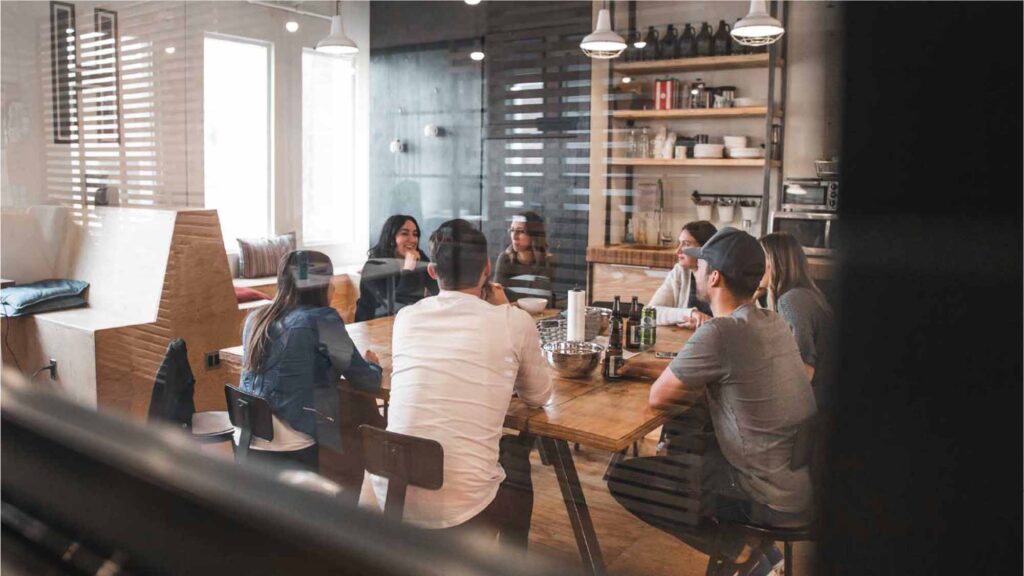 A group of people sat around a table, chatting.