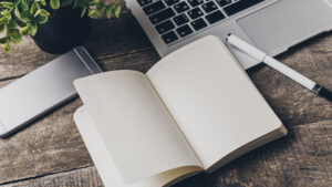 Notebook and laptop on old wooden desk