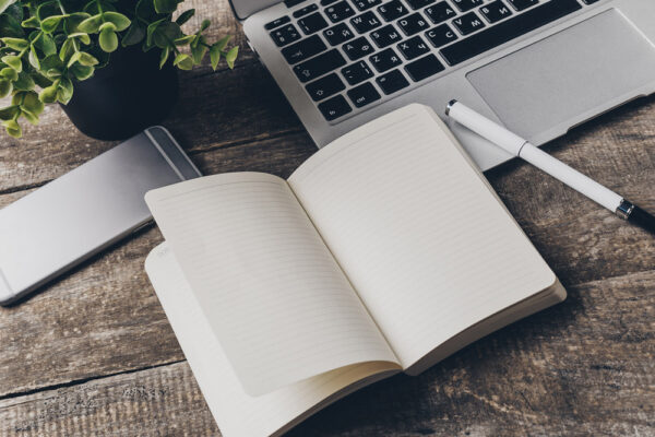 Notebook and laptop on old wooden desk