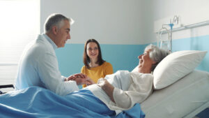 doctor meeting a senior patient on a hospital bed and her daughter