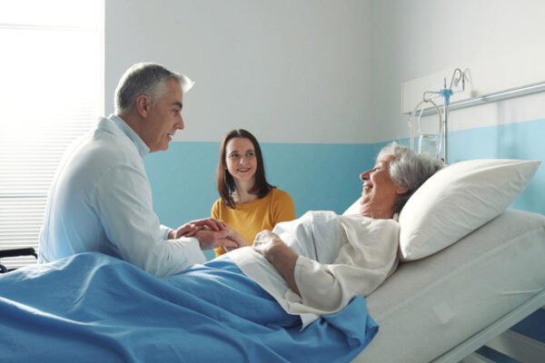 doctor meeting a senior patient on a hospital bed and her daughter