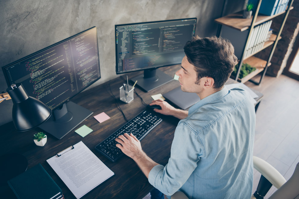 Man looking at computer screens.