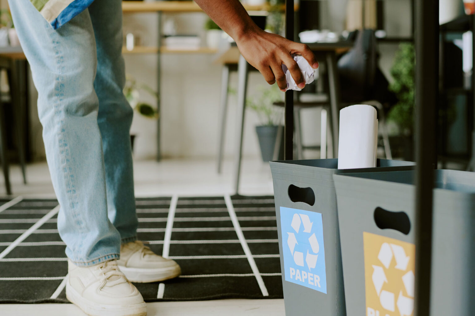 Person putting paper in recycling bin