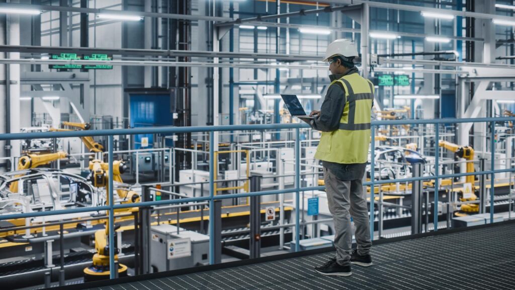 Engineer in High Visibility Vest Using Laptop